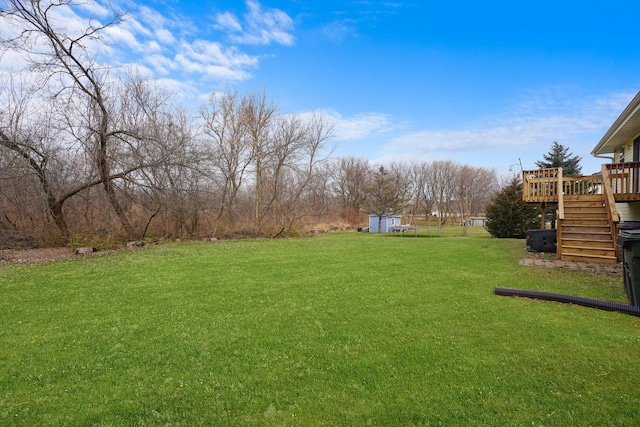 view of yard featuring a deck and a storage unit