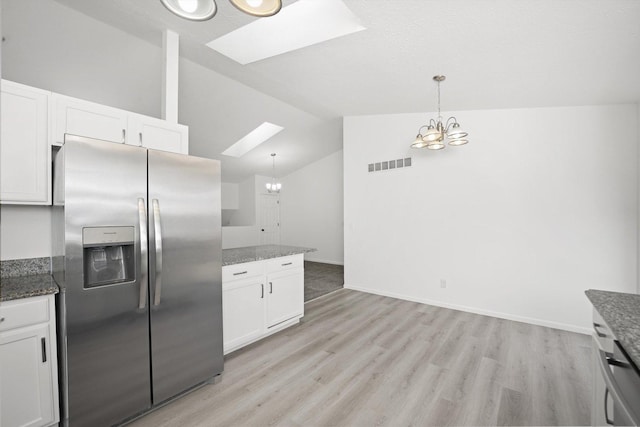 kitchen featuring hanging light fixtures, stainless steel refrigerator with ice dispenser, and white cabinets