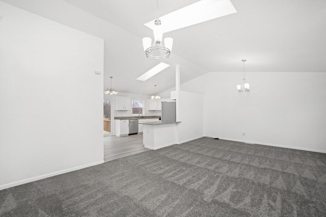 unfurnished living room featuring an inviting chandelier, vaulted ceiling with skylight, and dark carpet