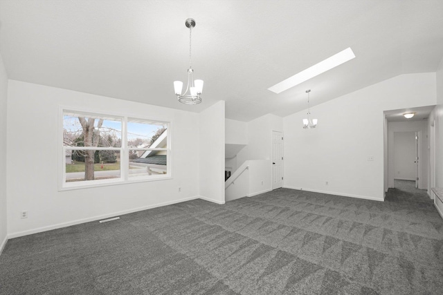 unfurnished living room with dark colored carpet, lofted ceiling with skylight, and an inviting chandelier