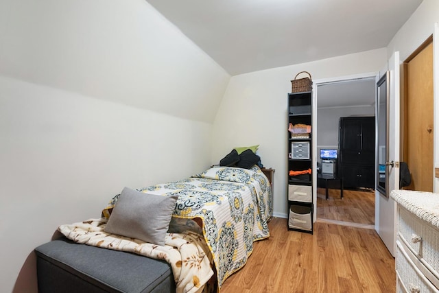 bedroom with lofted ceiling and light wood-type flooring