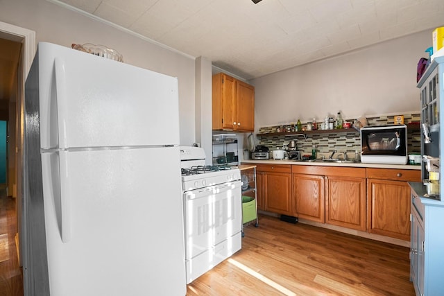 kitchen featuring sink, white appliances, and light hardwood / wood-style floors