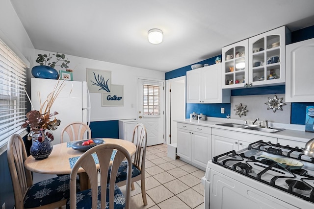 kitchen featuring white cabinetry, sink, white appliances, and light tile patterned floors