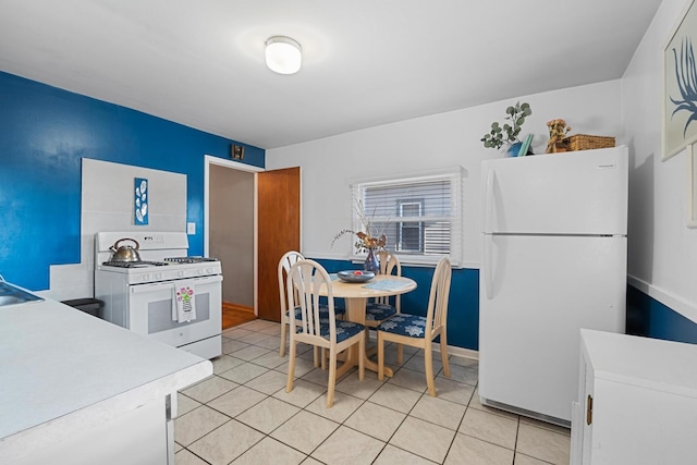 kitchen with white appliances, sink, and light tile patterned floors