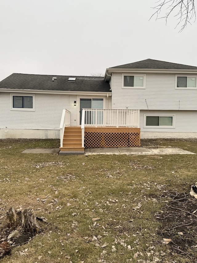 rear view of house with a deck and a lawn