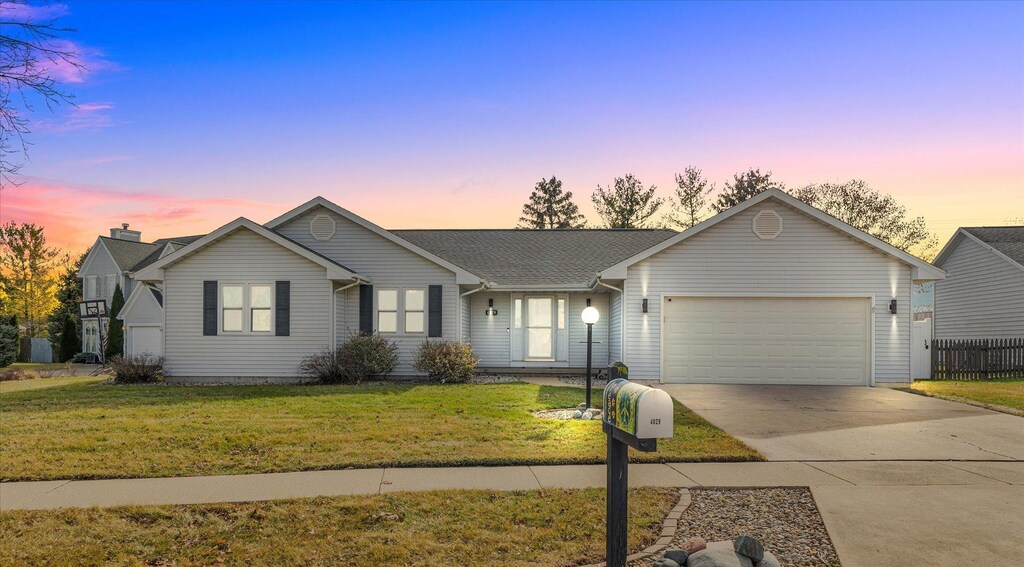 ranch-style home with a yard and a garage