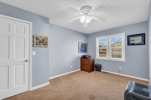 miscellaneous room featuring a textured ceiling, light colored carpet, and ceiling fan