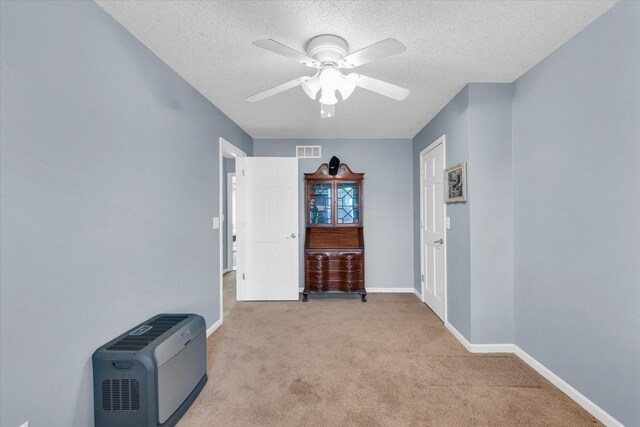 carpeted spare room with ceiling fan and a textured ceiling
