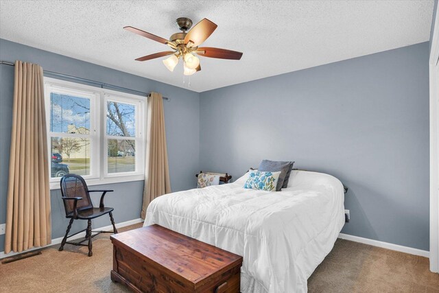 bedroom with light carpet, ceiling fan, and a textured ceiling