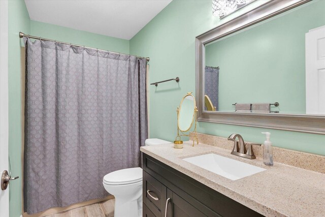 bathroom with hardwood / wood-style flooring, vanity, and toilet