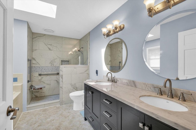 bathroom with vanity, toilet, a skylight, and a tile shower