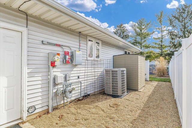 view of side of property with cooling unit and a storage unit