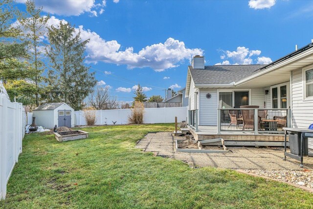 view of yard featuring a deck and a storage shed