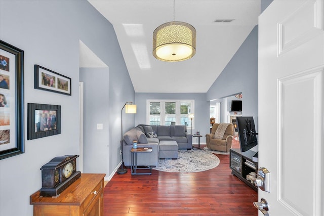 living room featuring dark wood-type flooring and high vaulted ceiling