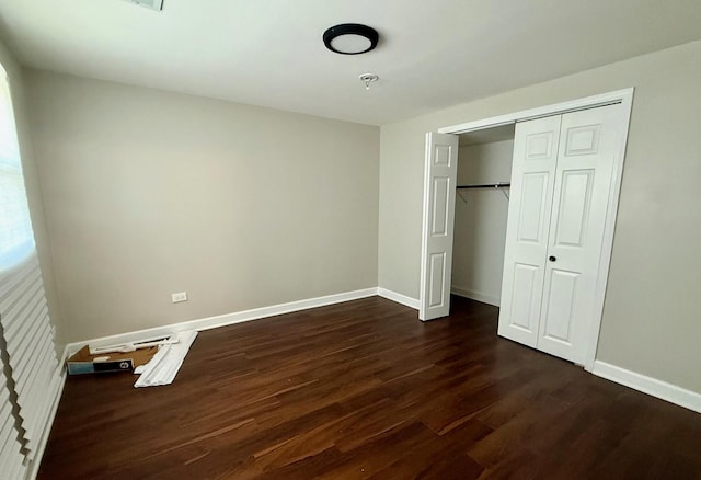 unfurnished bedroom with a closet and dark hardwood / wood-style floors