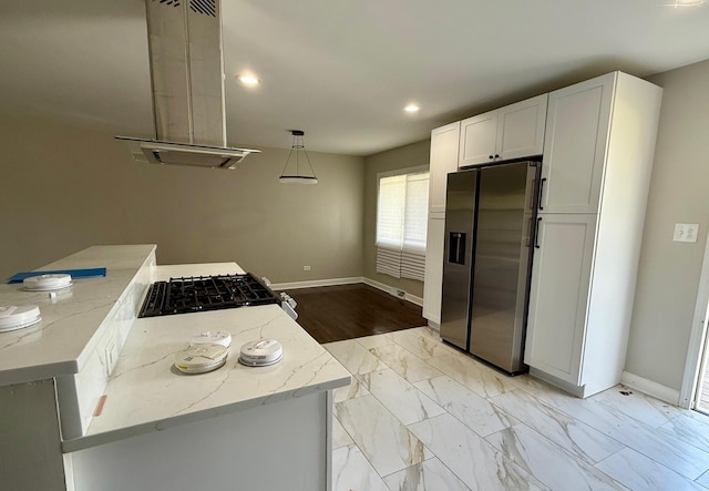 kitchen with decorative light fixtures, white cabinets, range, light stone counters, and stainless steel refrigerator with ice dispenser