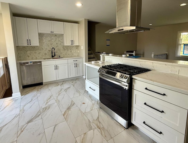 kitchen featuring appliances with stainless steel finishes, tasteful backsplash, white cabinetry, sink, and island exhaust hood