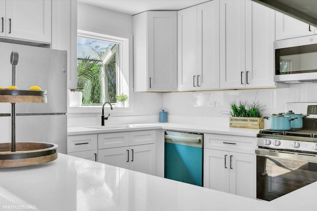 kitchen featuring tasteful backsplash, sink, stainless steel appliances, and white cabinets