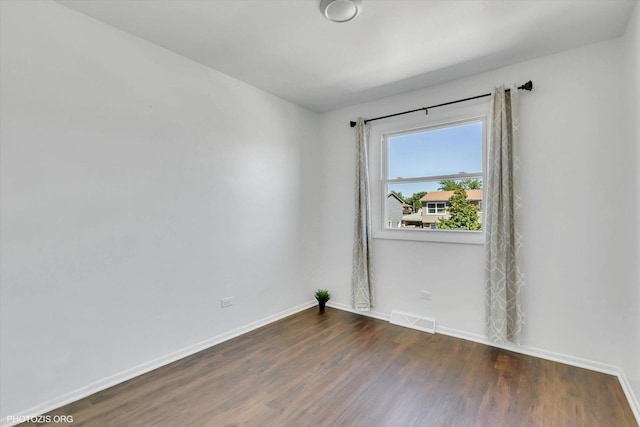 spare room with dark wood-type flooring