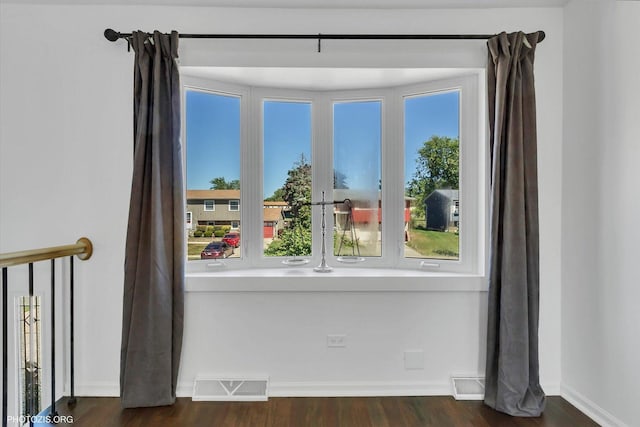 unfurnished room with dark hardwood / wood-style flooring and a healthy amount of sunlight