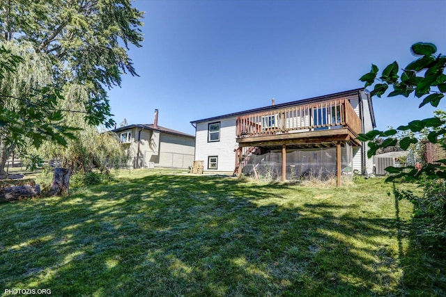 rear view of house with a lawn and a deck