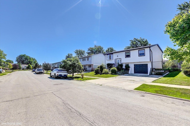 split foyer home featuring a garage and a front lawn