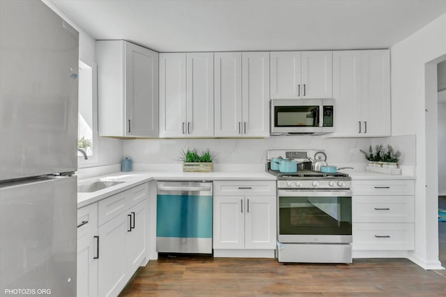 kitchen with white cabinetry, stainless steel appliances, dark wood-type flooring, and sink