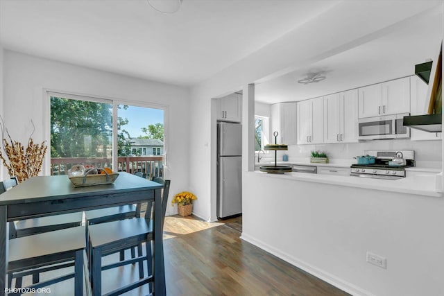 kitchen featuring dark hardwood / wood-style flooring, stainless steel appliances, and white cabinets