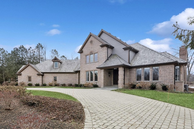 view of front of house with central AC and a front lawn