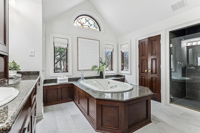 bathroom with vanity, separate shower and tub, and vaulted ceiling