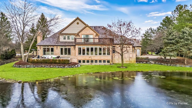 back of house featuring a yard, a patio area, a balcony, and a water view