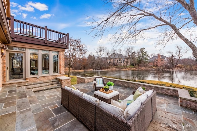 view of patio with a water view, a balcony, and outdoor lounge area