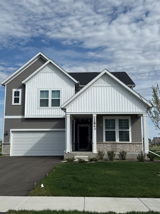 12929 S Beckham Dr, Plainfield, IL 60585 - view of front facade with board and batten siding, a porch, a garage, stone siding, and a front lawn