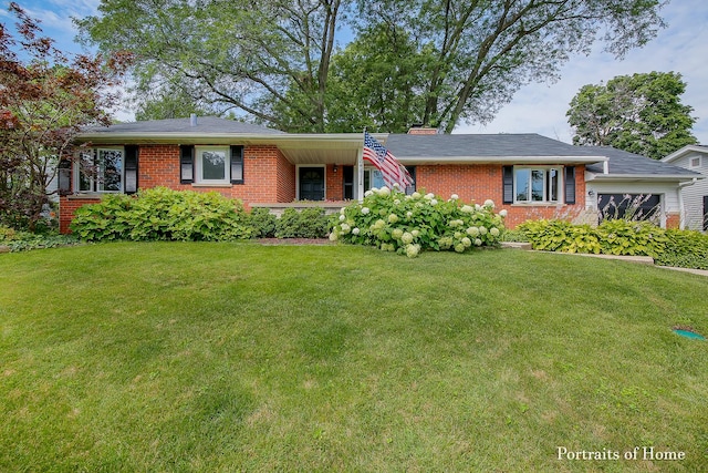 ranch-style home with a garage, brick siding, and a front lawn