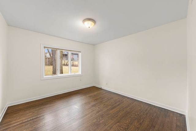 empty room with dark wood-style floors and baseboards