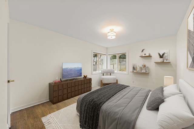 bedroom with baseboards and wood finished floors