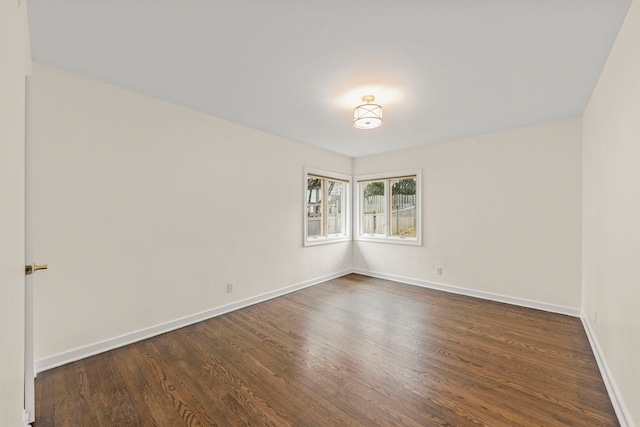 spare room with dark wood finished floors and baseboards