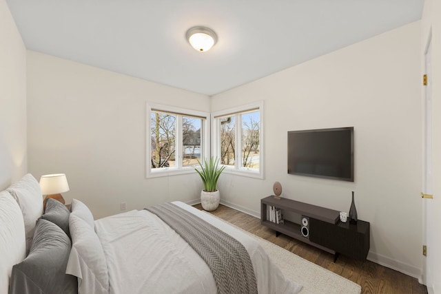 bedroom featuring baseboards and wood finished floors