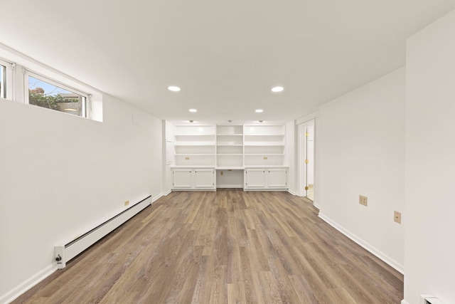 spare room featuring baseboards, baseboard heating, light wood-style flooring, and recessed lighting