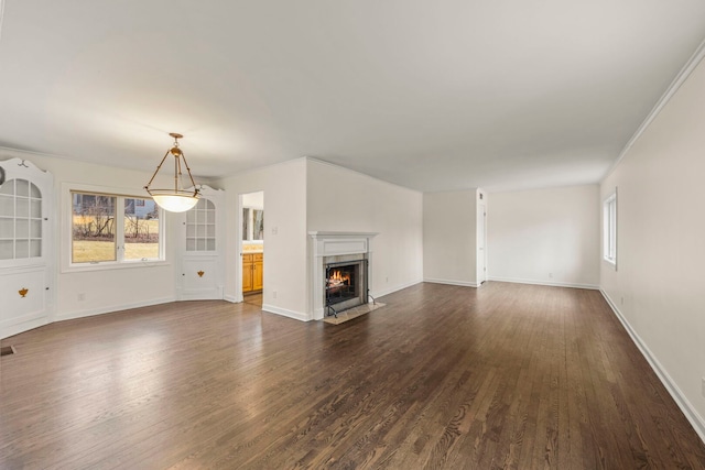 unfurnished living room featuring visible vents, dark wood finished floors, a high end fireplace, and baseboards