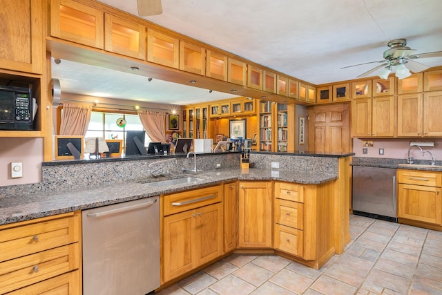 kitchen featuring dark stone countertops, sink, stainless steel dishwasher, and ceiling fan