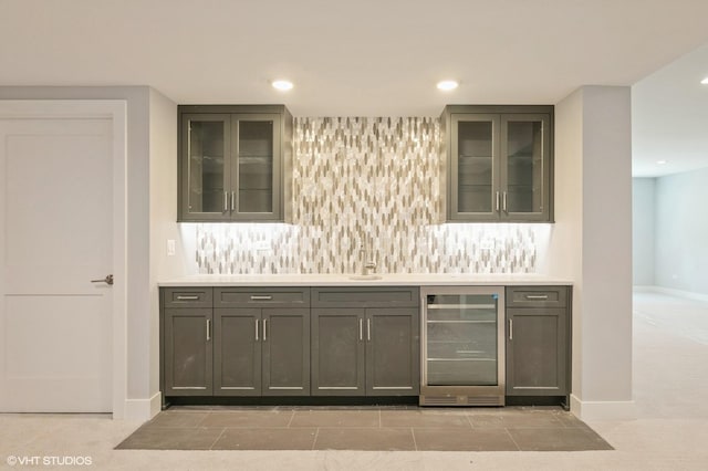 bar with light carpet, gray cabinetry, and beverage cooler