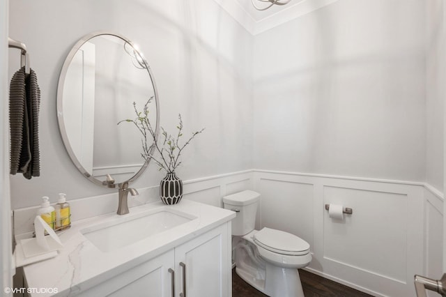 bathroom with ornamental molding, vanity, toilet, and hardwood / wood-style floors