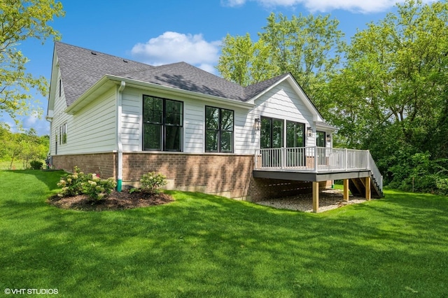 rear view of property with a yard and a deck