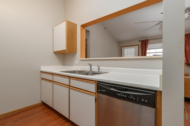 kitchen featuring white cabinetry, light wood finished floors, stainless steel dishwasher, a sink, and light countertops