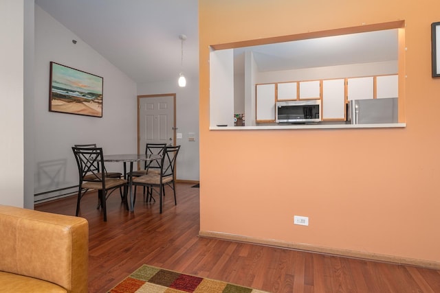 interior space with lofted ceiling, baseboards, wood finished floors, and a baseboard radiator