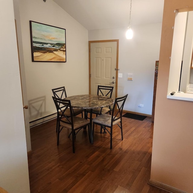 dining area with baseboard heating, dark hardwood / wood-style floors, and vaulted ceiling