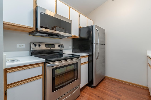 kitchen featuring white cabinets, light countertops, stainless steel appliances, baseboards, and light wood-type flooring