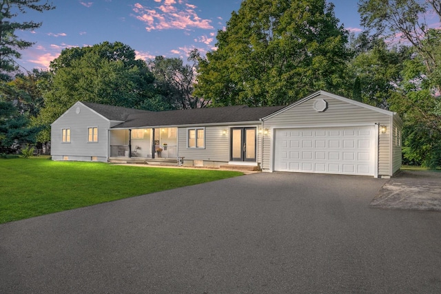 single story home with a garage and a yard