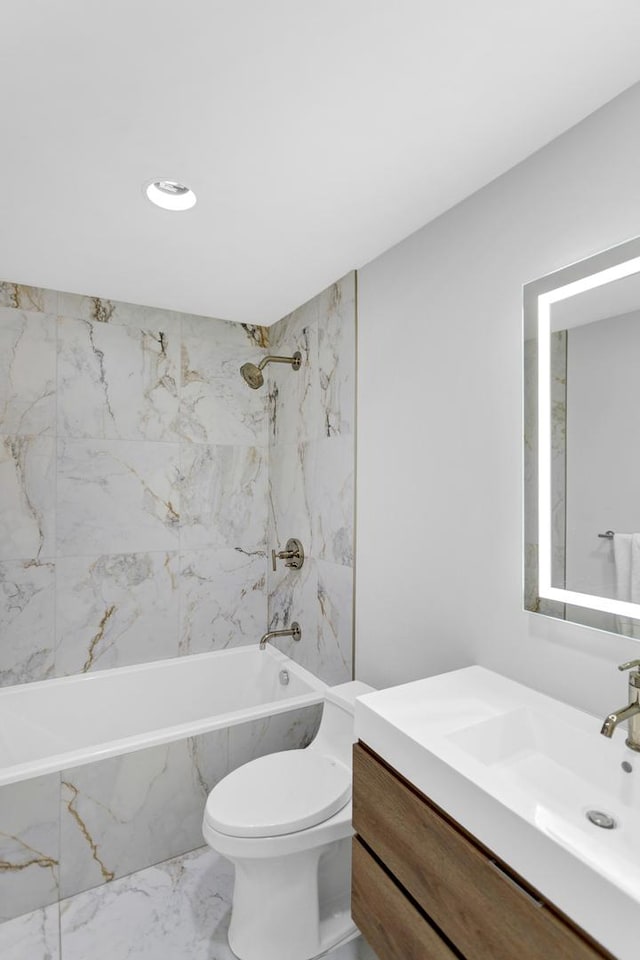 full bathroom featuring vanity, tiled shower / bath combo, and toilet